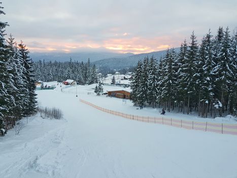 Ski and sled slope in winter resort, mountain winter landscape in Romanian Carpathians.
