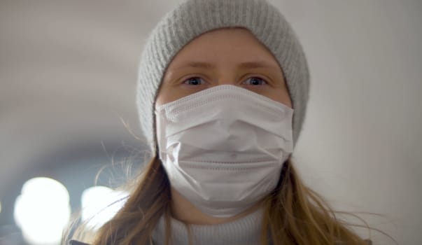Portrait of young woman in protective mask on the subway escalator. Coronavirus epidemic in the city. Healthy and safety lifestyle concept. Covid-19 pandemic