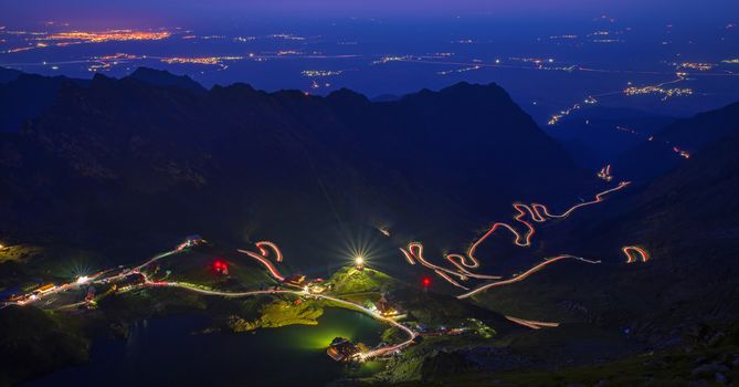 Long exposure on summer mountain, Balea Lake, winding road of Transfagarasan and valley lights