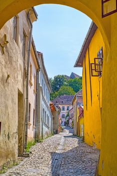 Stone paved street and colorful houses in a medieval citadel, Sighisoara in Romania