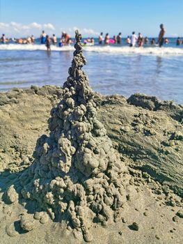 Wet sand castle and blurred croded beach background