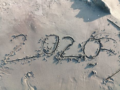 Happy year 2020 in wet sandy beach