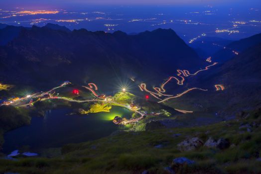 Night mountain landscape: winding road and glacier lake in Romanian Carpathians, Balea lake touristic destination