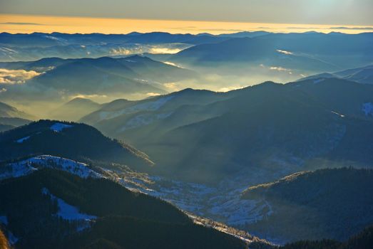 Misty mountain landscape in Romanian Carpathians, winter top view