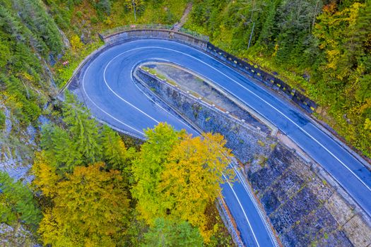 Above view of autumn trees and curvy road. Bicaz Gorges are a mountain pass between two historic region in Romania.