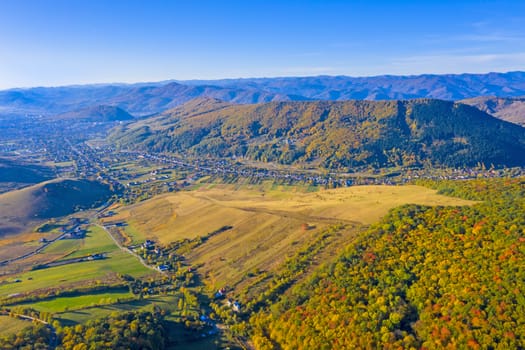 Aerial view of forest and rural village in a beautiful autumn landscape