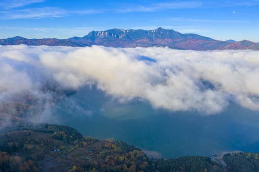 Mist cloud over mountain lake in autumn, Romanian Carpathians.