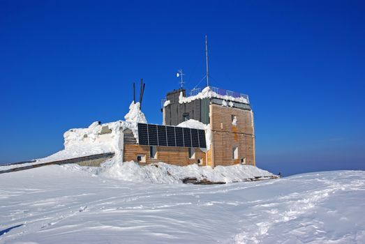 Winter mountain refugee with solar cells on the summit, Romanian Carpathians
