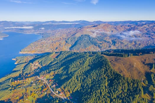 Autumn aerial view of mountain lake and villages from the valley in Romanian Carpathians, Bicaz Lake