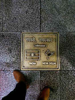 India, New Delhi plaque on the streets of Itaewon with a pair of legs in brown boots