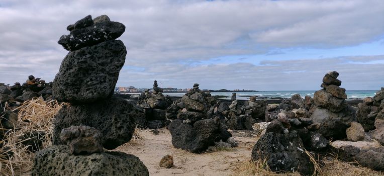 Wish rocks of black color on the shore of hyeopjae beach in Jeju Island, South Korea.