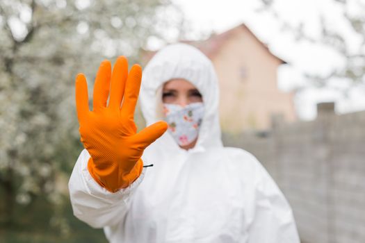 Woman in black mask, white protective suit and gloves