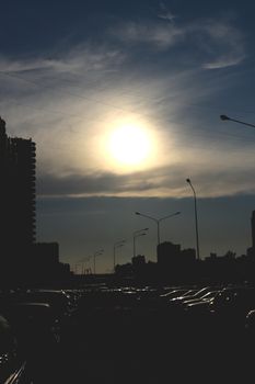 The bright sun in the clear sky illuminates many cars in the sleeping area