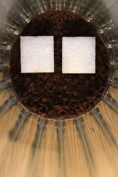 Two pieces of sugar in a glass with an insoluble coffee