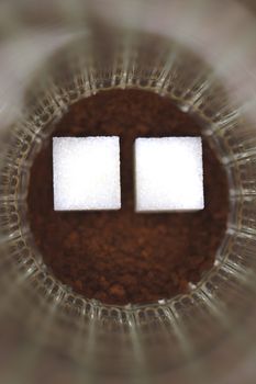 Two pieces of sugar in a glass with an insoluble coffee