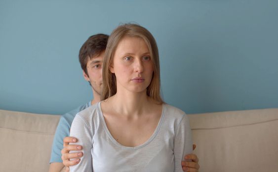 Portrait of beautiful family indoors. Husband helping his wife to relax.