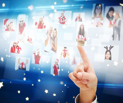 Composite image of hand pointing to christmas people collage against bright star pattern on blue