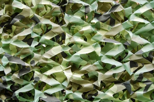 Camouflage fabric covering a garden fence to provide privacy.