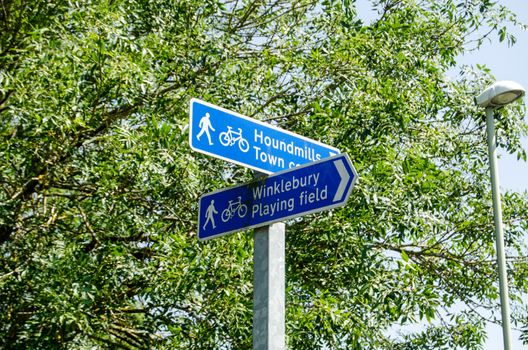 Fingerpost direction signs for pedestrians and cyclists in Basingstoke, Hampshire. Sunny summer day.