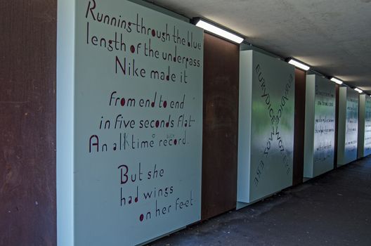 Basingstoke, UK - July 23, 2019: Pedestrian and traffic underpass crossing the path of the River Loddon in Basingstoke, Hampshire. The poem on the wall notes the ancient waterway.  