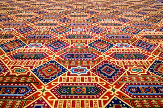 Colourful patterened carpet, focus on foreground with diminishing perspective.