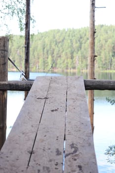 Spellbinding jumping path under lake with pine forest around.