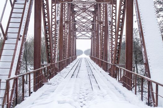 Winter landscape. Metall red bridge over the frozen river