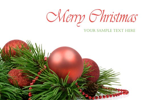 Minimalistic Christmas decoration - shiny red baubles and beads on pine twigs isolated on white background with copy space place (sample text).