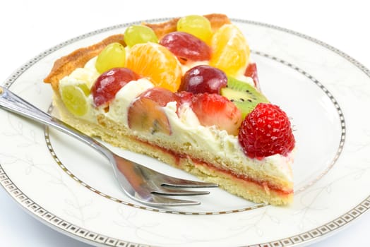 Fresh homemade multi fruit tart cake on a plate in close-up.