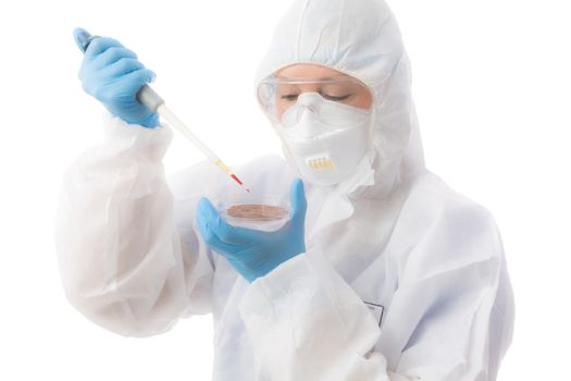 Female laboratory worker wearing protective hazmat biosecurity suit, gloves, respirator mask and goggles analyses samples