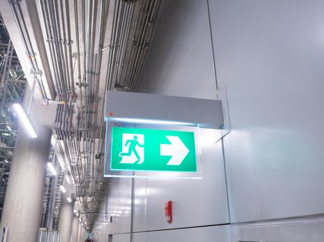 led sign in corridor point way out of resident apartment building, Fire warning exit with arrow symbol sign box light Emergency Exit