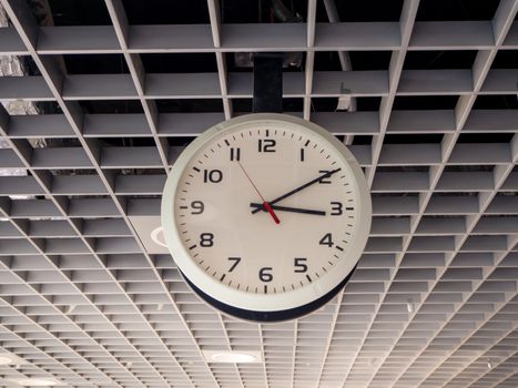 train station clock hanging from the ceiling.