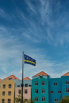 Curacao Flag by Colorful Buildings under nice sky