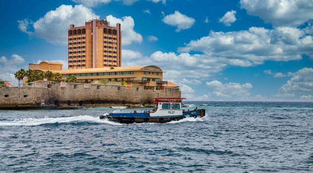 A pilot boat heading out to sea from the harbor on Curacao