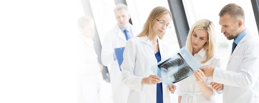 Team of experts doctors looking at MRI picture at hospital office meeting