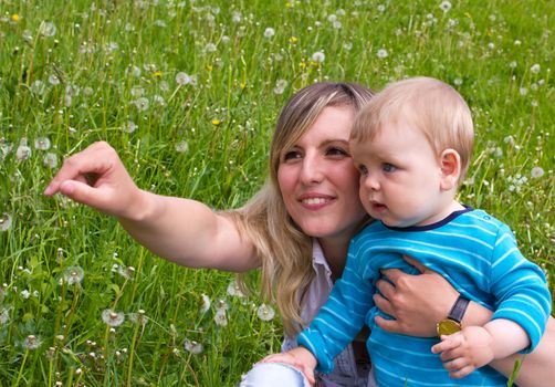 young mother with her son on the green grass