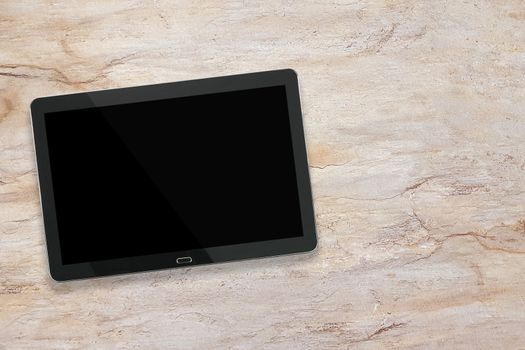 Mockup of a modern black silver digital tablet on a marble desk ( high angel view)