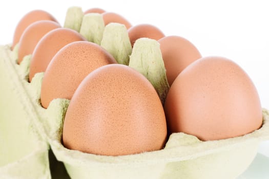 Ten eggs in a container in close up and isolated on white background