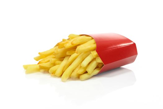 French fries in a red carton box in close-up and isolated on white background