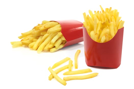 Group of french fries in a red carton boxes in close-up and isolated on white background.