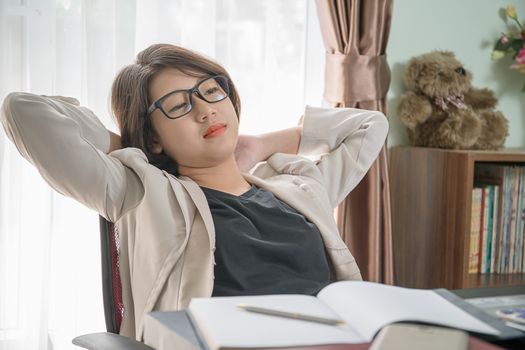 Teenage girl short hair relaxed after working on laptop while sit near window at home office