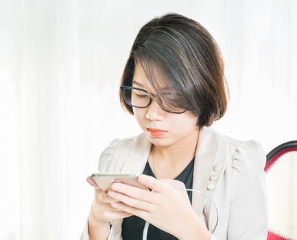 Teenage girl short hair in smart casual wear working on laptop while sit near window at home office