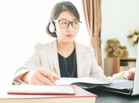 Teenage girl short hair in smart casual wear working on laptop while sit near window in home office