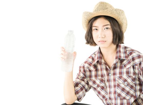 Young pretty woman in a cowboy hat and plaid shirt holding a water bottle isolated on white background