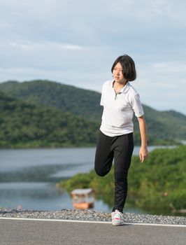 Fitness and lifestyle concept - Young asian woman short hair doing exercising outdoor