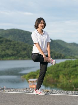 Fitness and lifestyle concept - Young asian woman short hair doing exercising outdoor