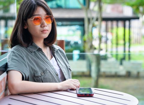 Pretty woman sitting in a cafe terrace use smartphone