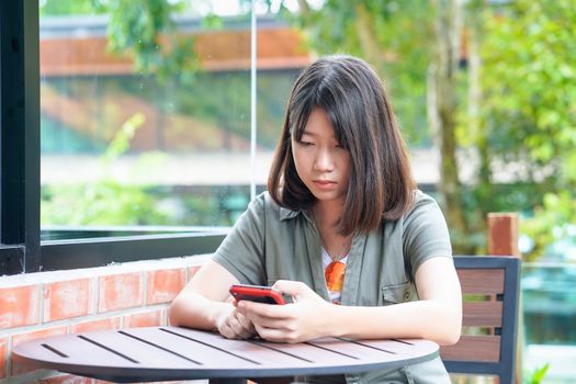 Pretty woman sitting in a cafe terrace use smartphone