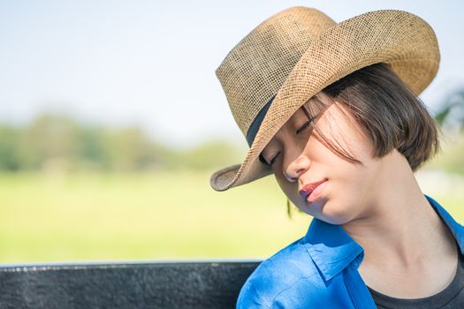 Young asian women short hair wear hat sit sleep in countryside Thailand