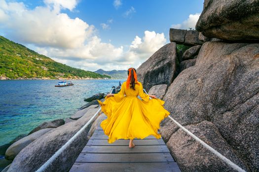 Beautiful girl running on wooden path at Koh Nang yuan island near Koh Tao island, Surat Thani in Thailand.